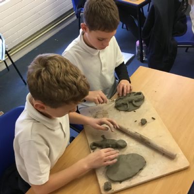 Children making clay lizards